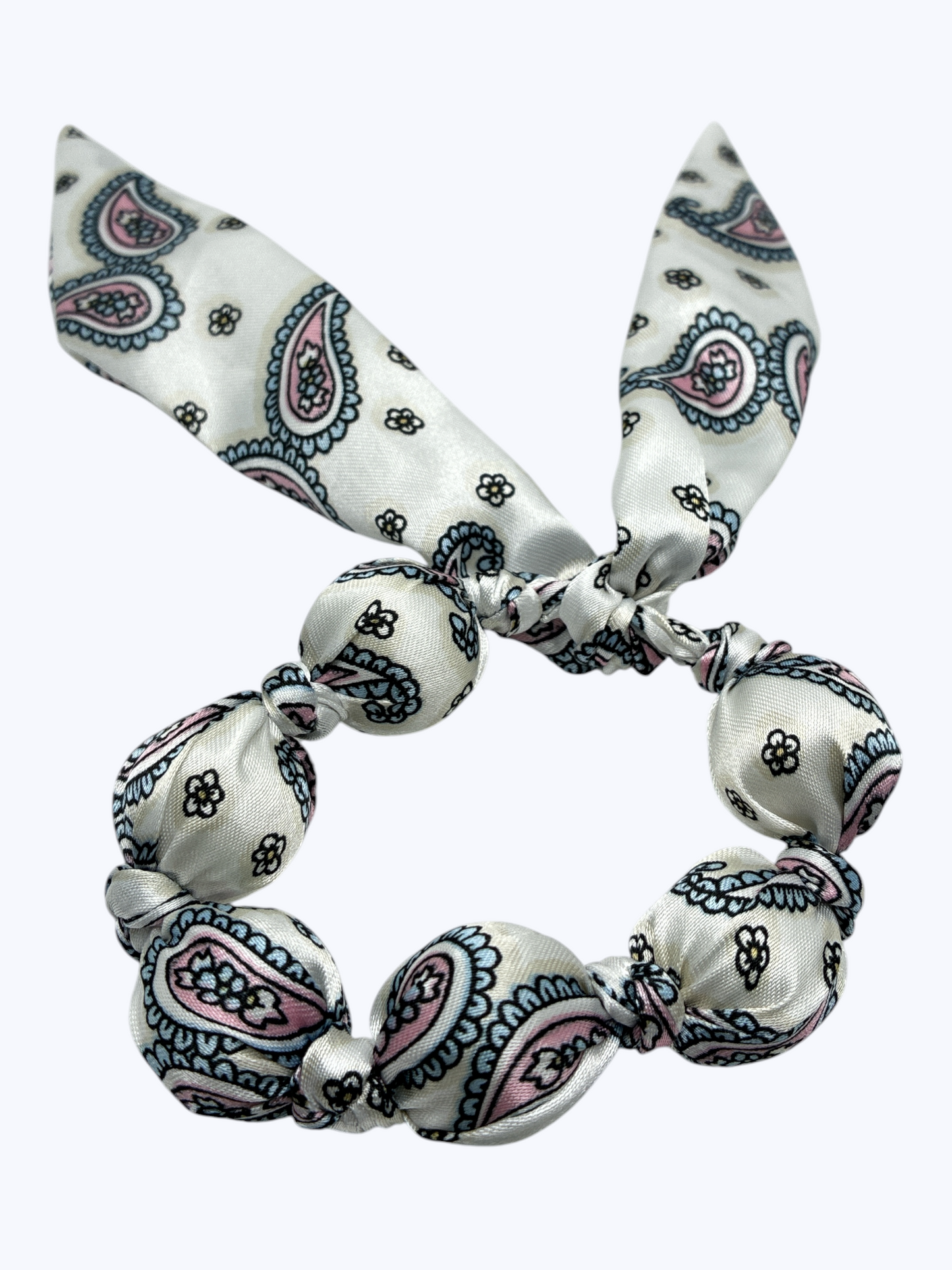 White hair tie with blue and pink paisley pattern on a white background