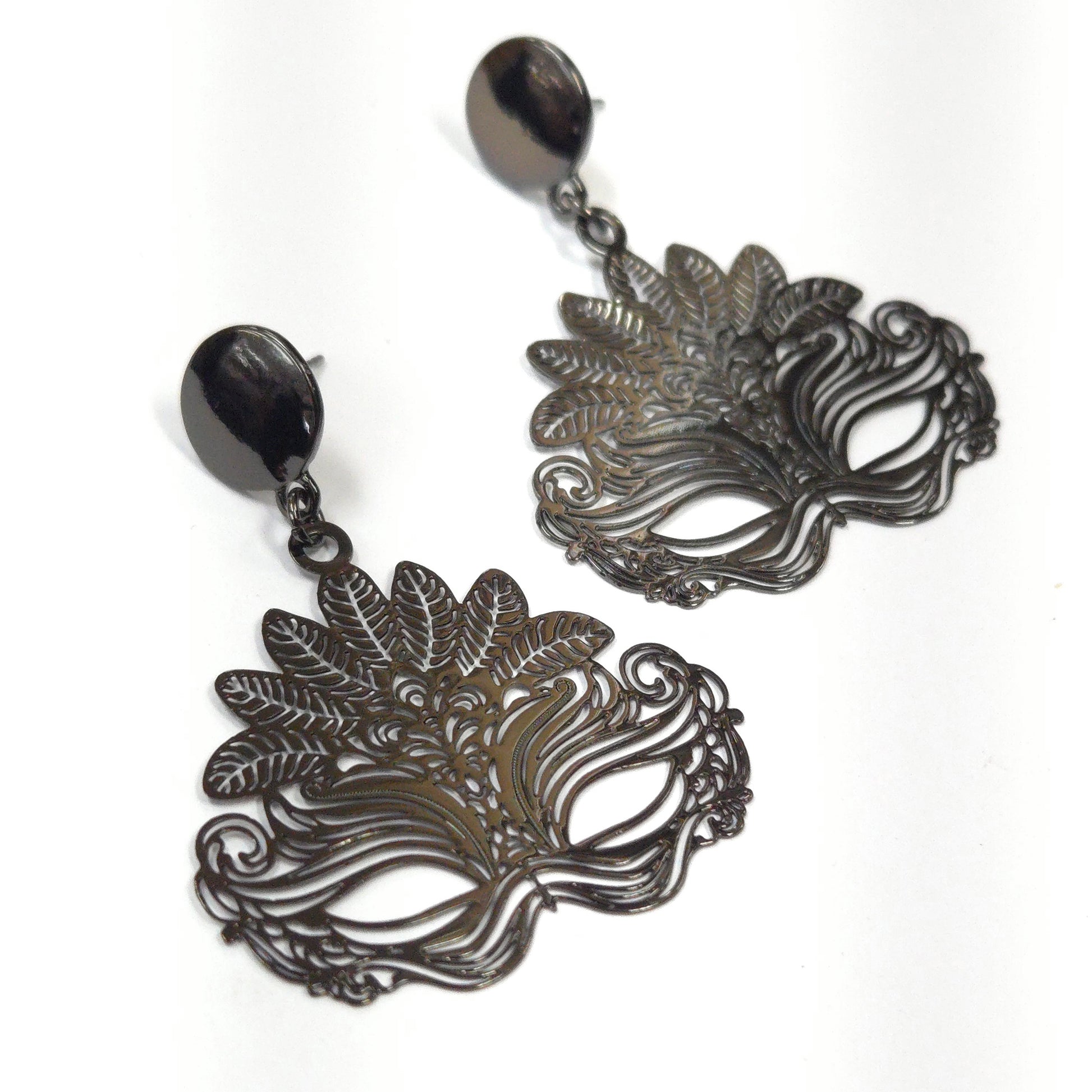 Pair of ornate mask-shaped earrings on a white background