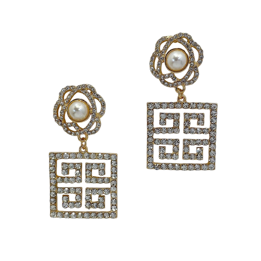 Pair of earrings with geometric designs and pearl-like centers on a white background