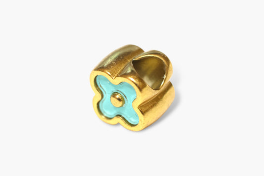 Gold charm with a turquoise clover design on a white background