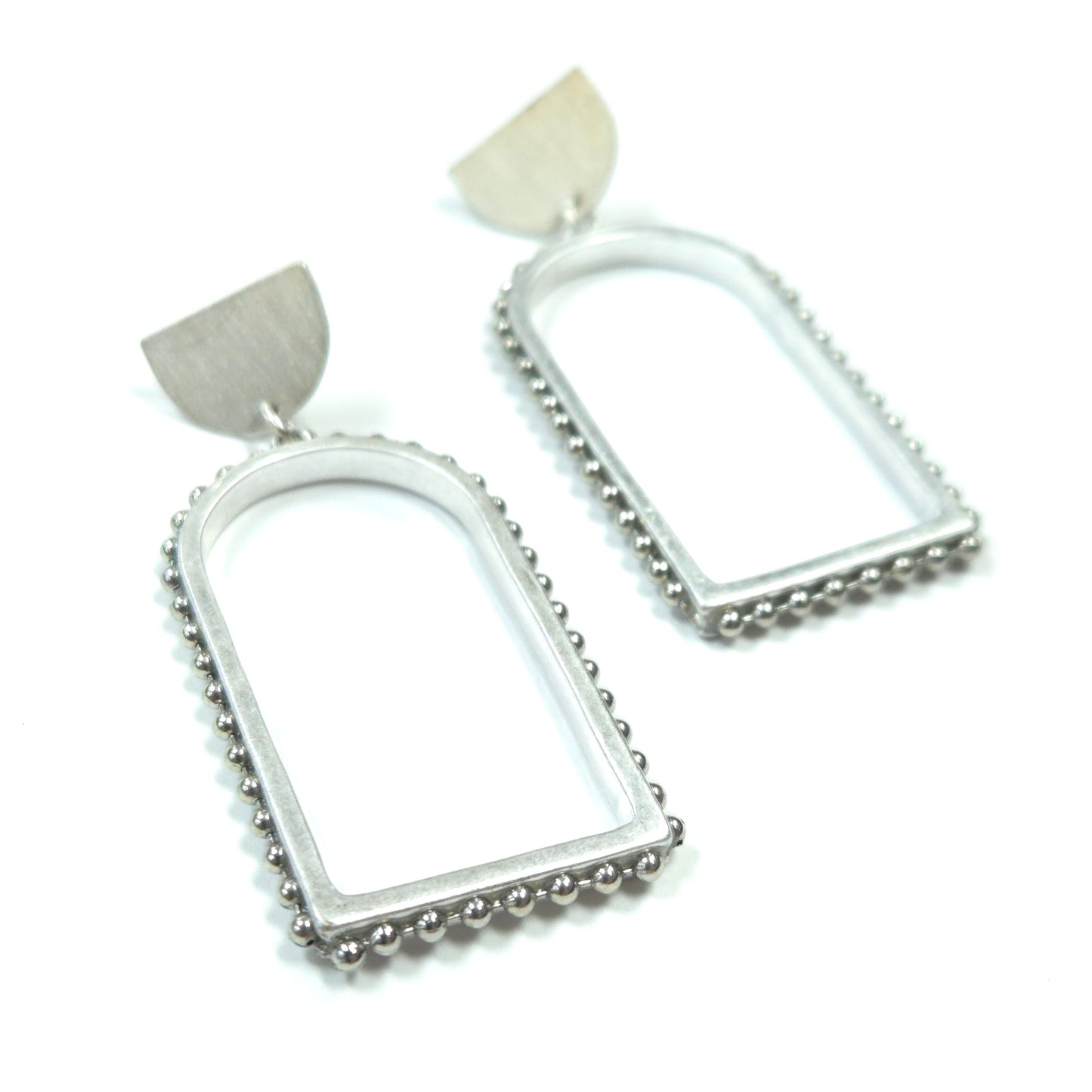 Pair of silver hoop earrings with tassels on a white background