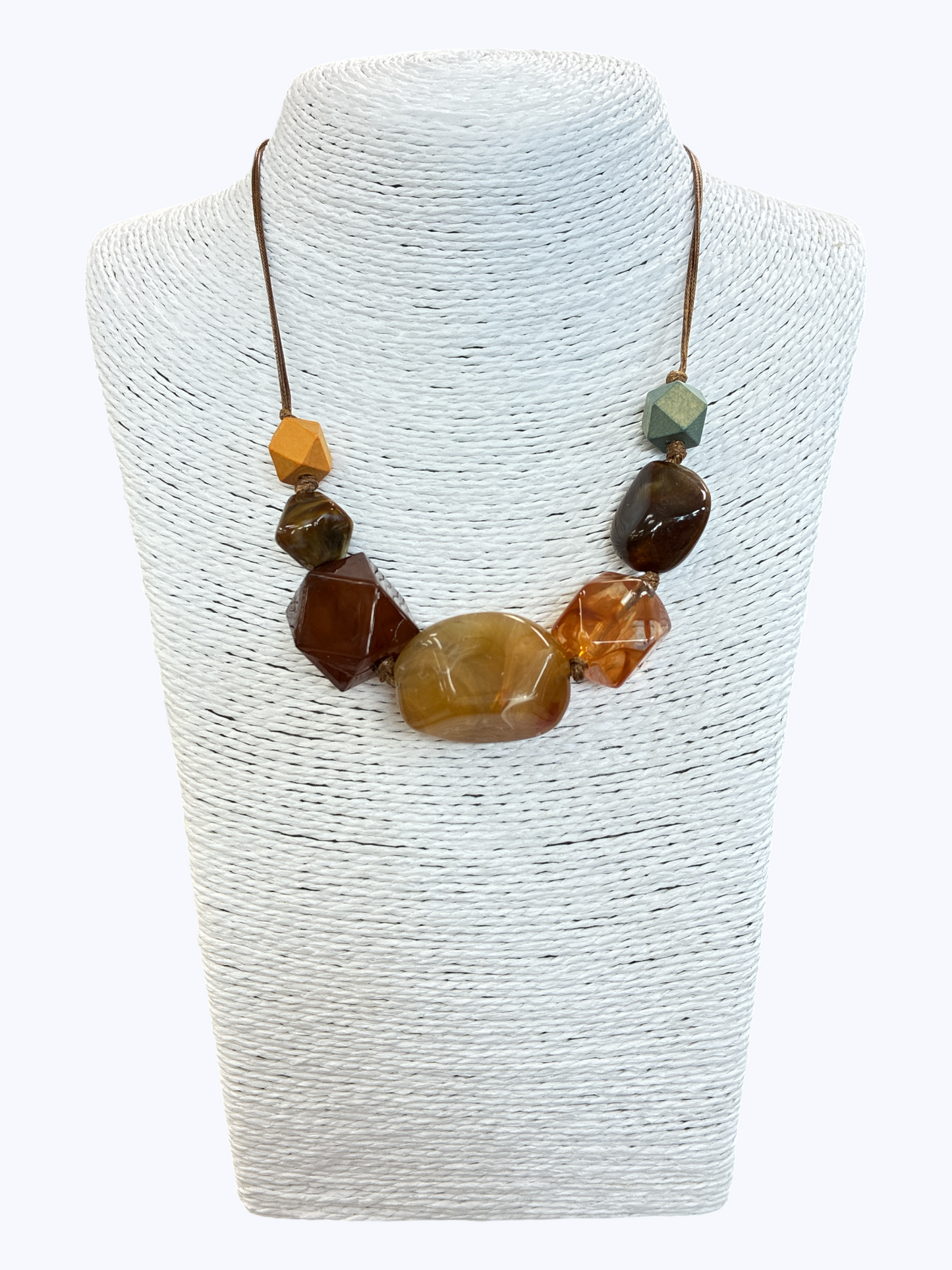 Earth-tone statement bead necklace with glossy marbled resin accents and geometric details on brown cord for a warm artisan boutique look.