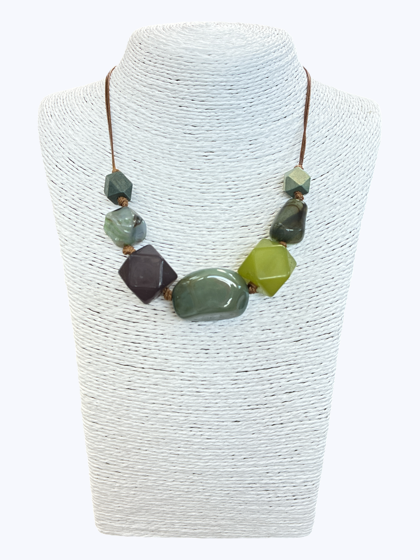 Green statement bead necklace with glossy marbled resin accents and geometric details on brown cord for a modern earthy boutique-inspired style.
