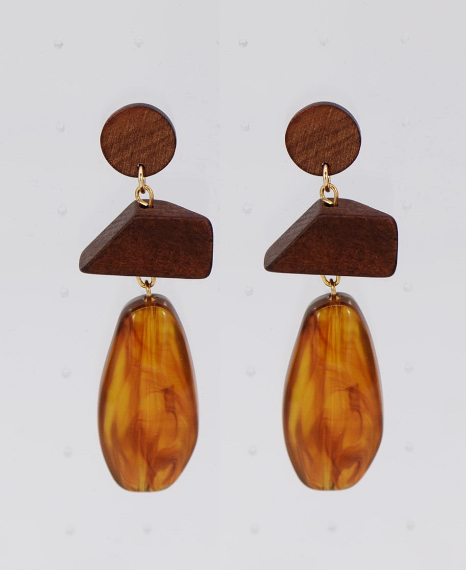 Wooden earrings with brown teardrop-shaped beads on a light gray background