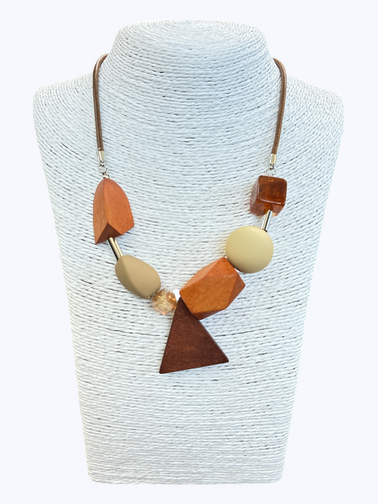 Earth-tone geometric statement necklace with abstract resin and wood-inspired beads on brown cord for a contemporary artisan boutique style.