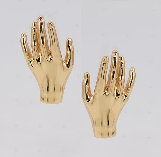 Gold hand-shaped earrings on a light gray background