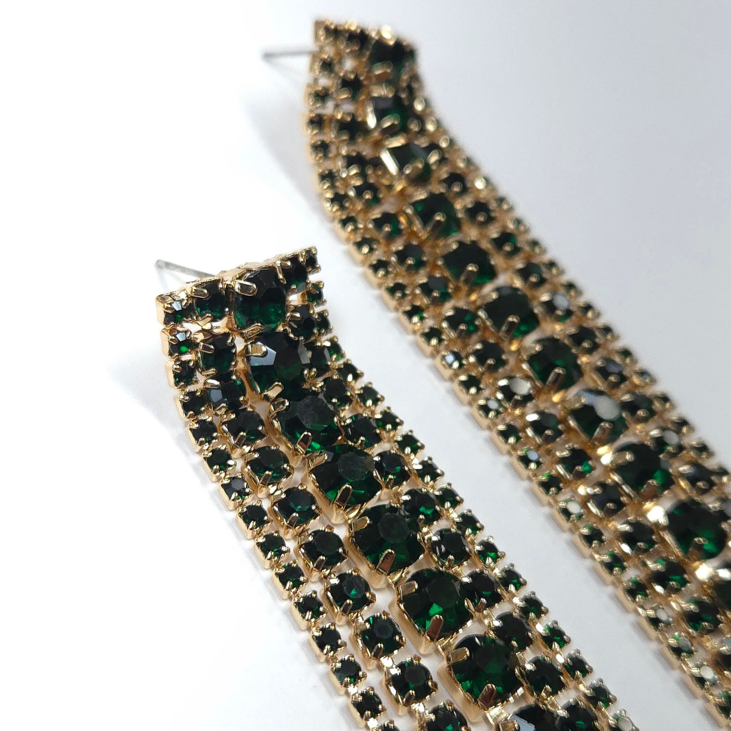 Gold and green rhinestone earrings on a white background
