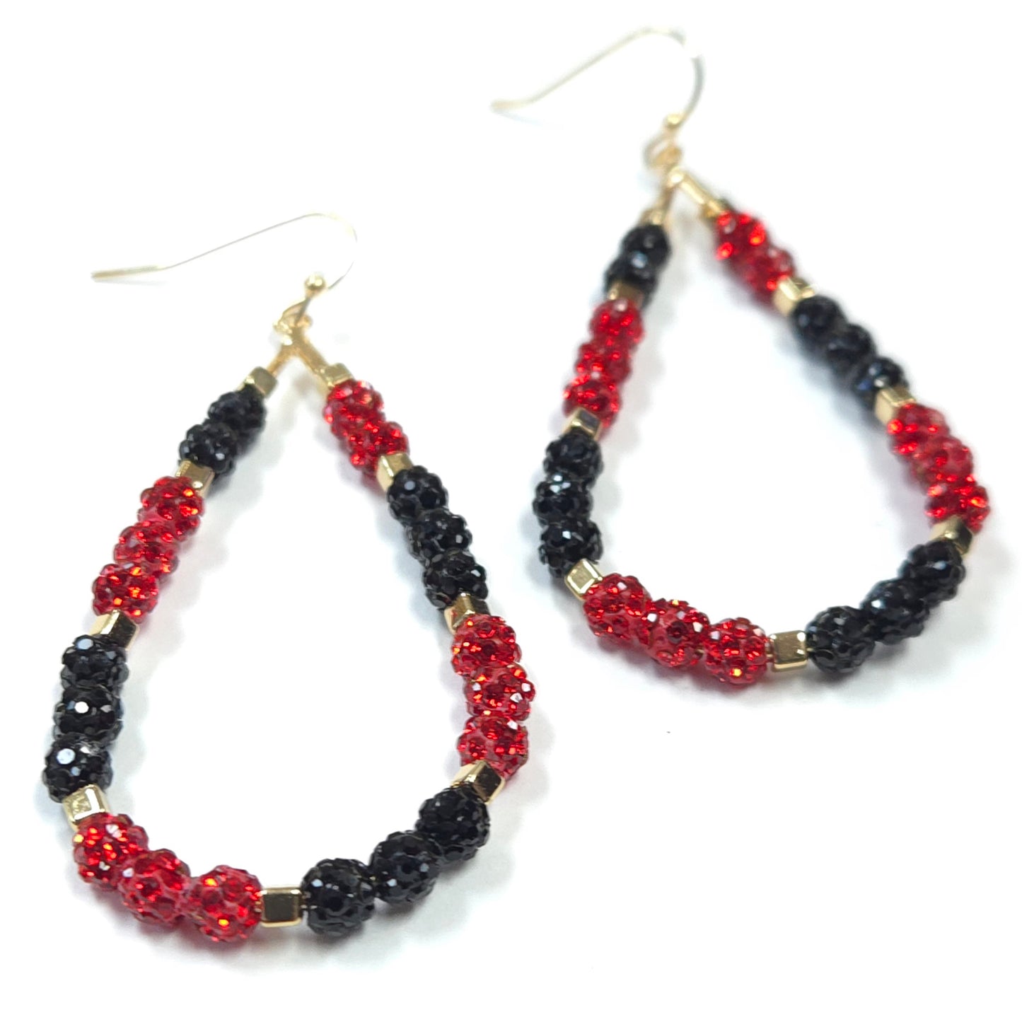 Pair of hoop earrings with red and black beads on a white background