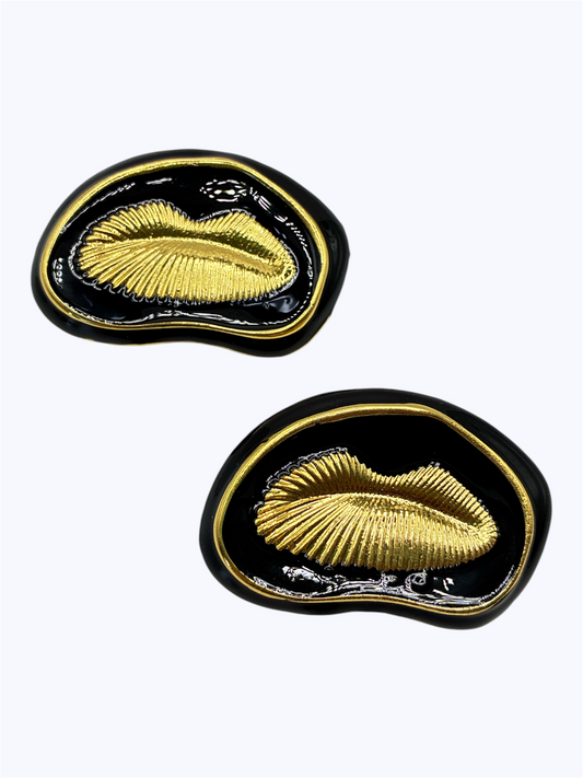 Black and gold seashell statement earrings with glossy enamel detailing and an abstract organic shape