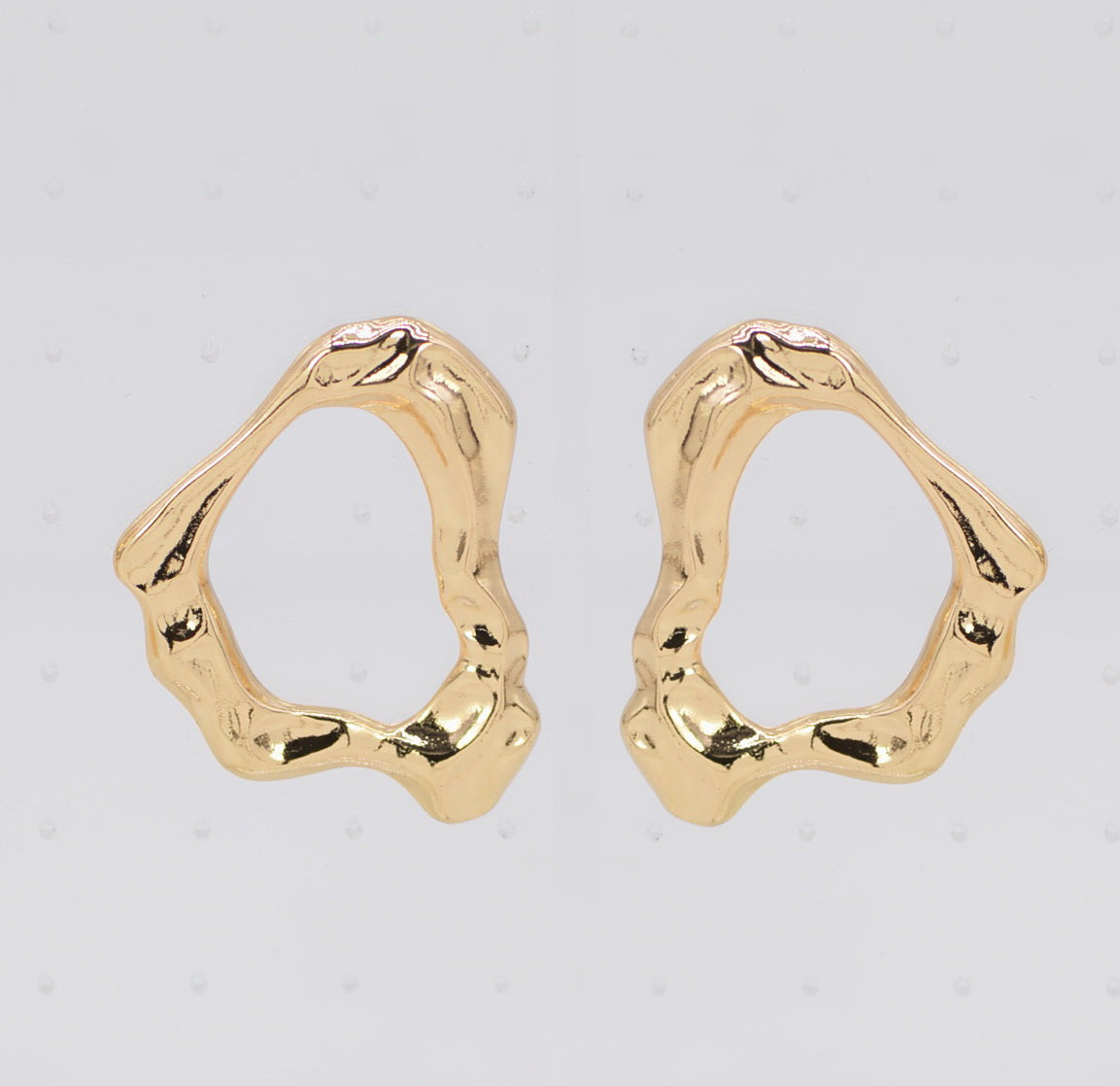 Gold hoop earrings on a light gray background