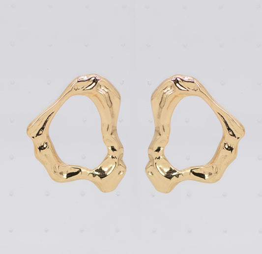 Gold hoop earrings on a light gray background