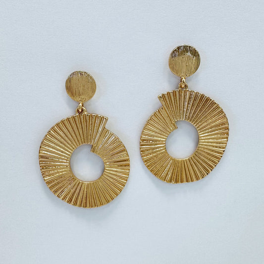 A pair of gold-colored drop dangle earrings with a textured surface, displayed against a white background.