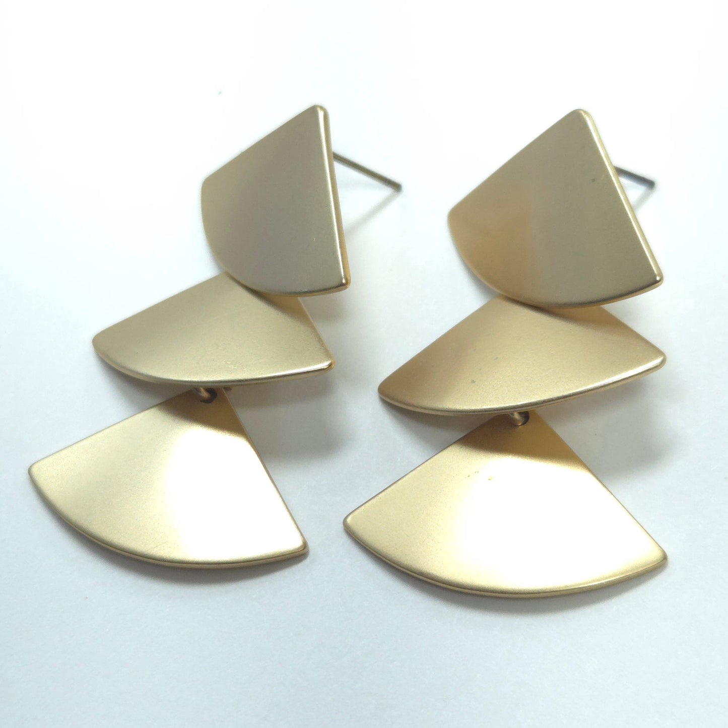 Gold geometric earrings on a white background