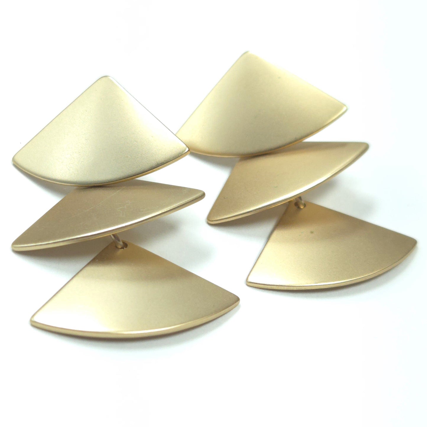 Set of gold triangular earrings on a white background