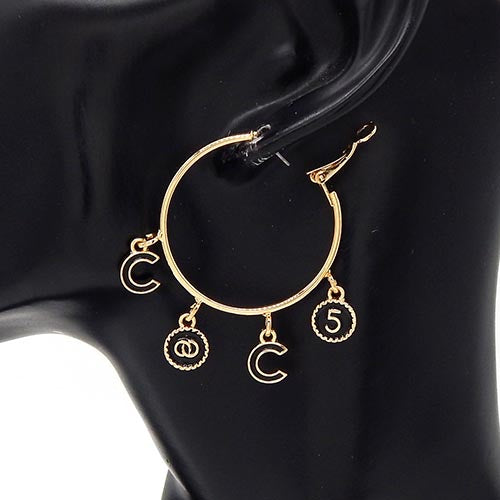 Gold hoop earrings with charms on a black background