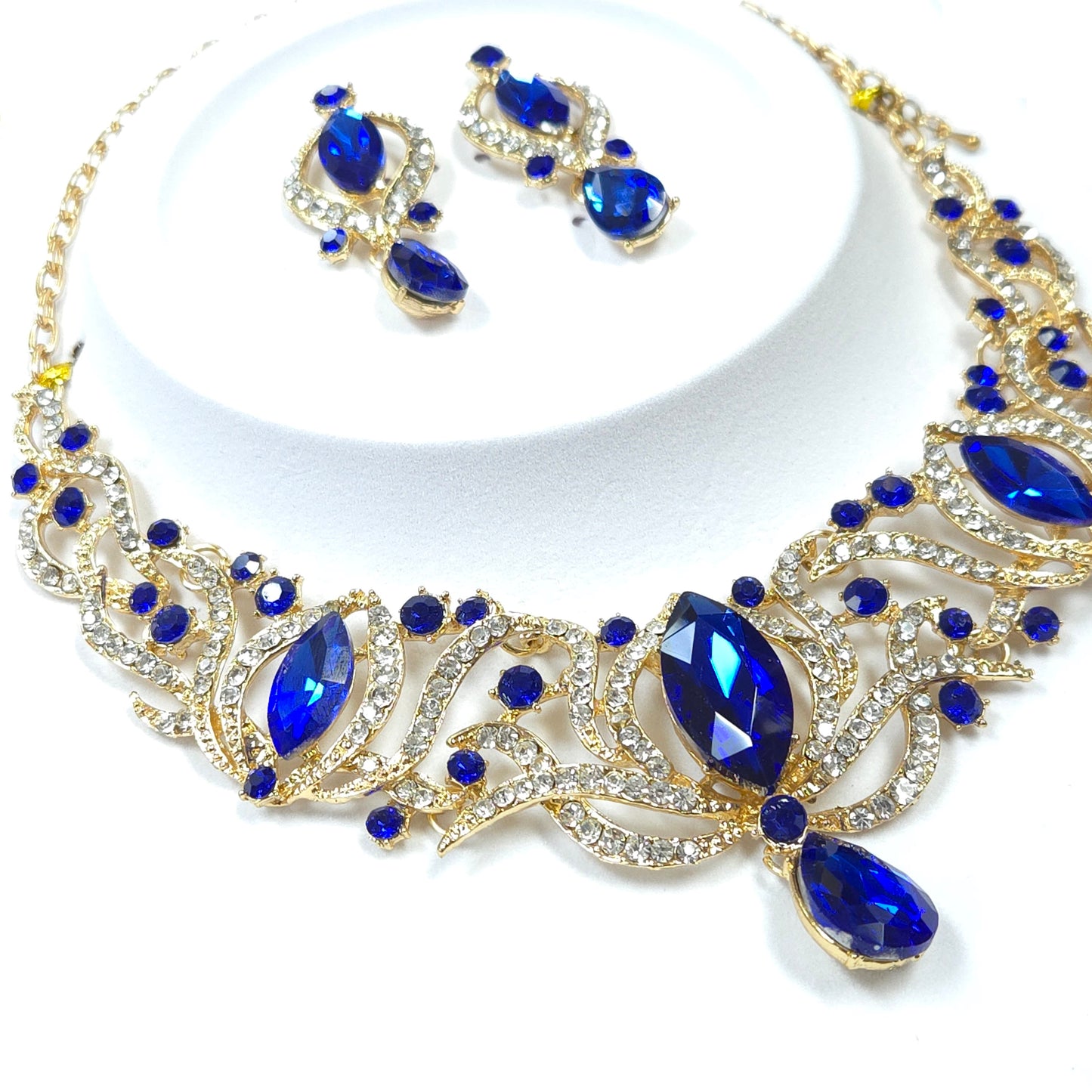 Jewelry set with blue stones and gold accents on a white background