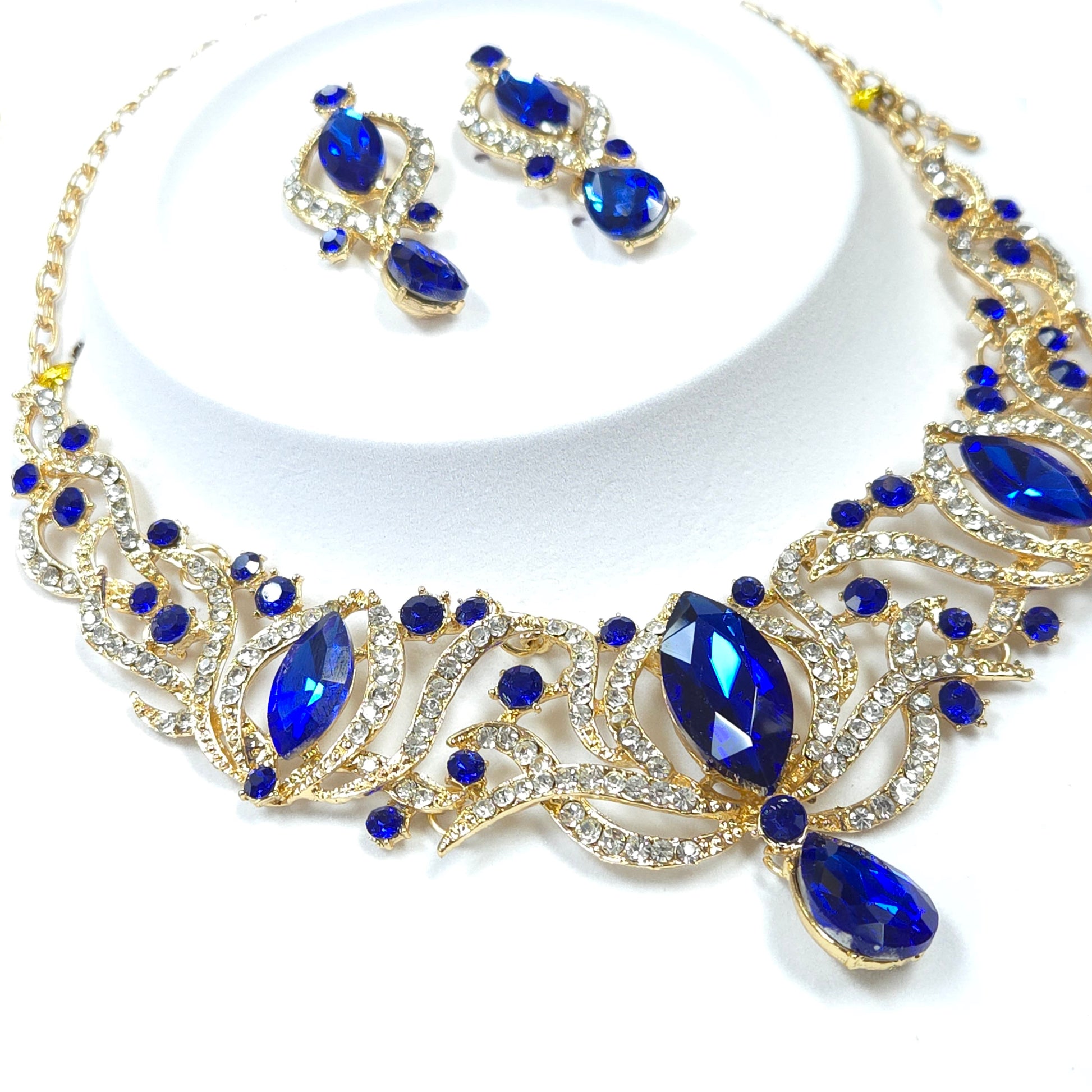Jewelry set with blue stones and gold accents on a white background