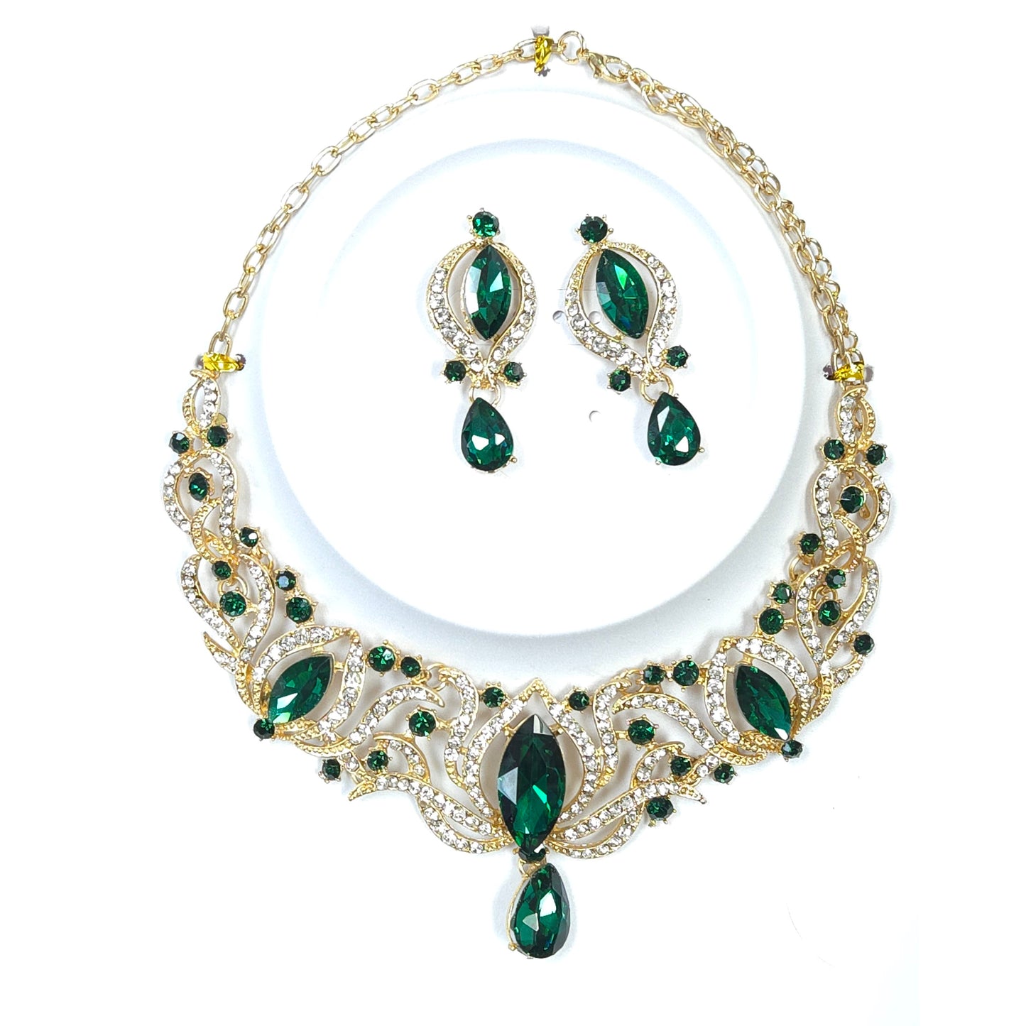Jewelry set with necklace and earrings featuring green gemstones on a white background