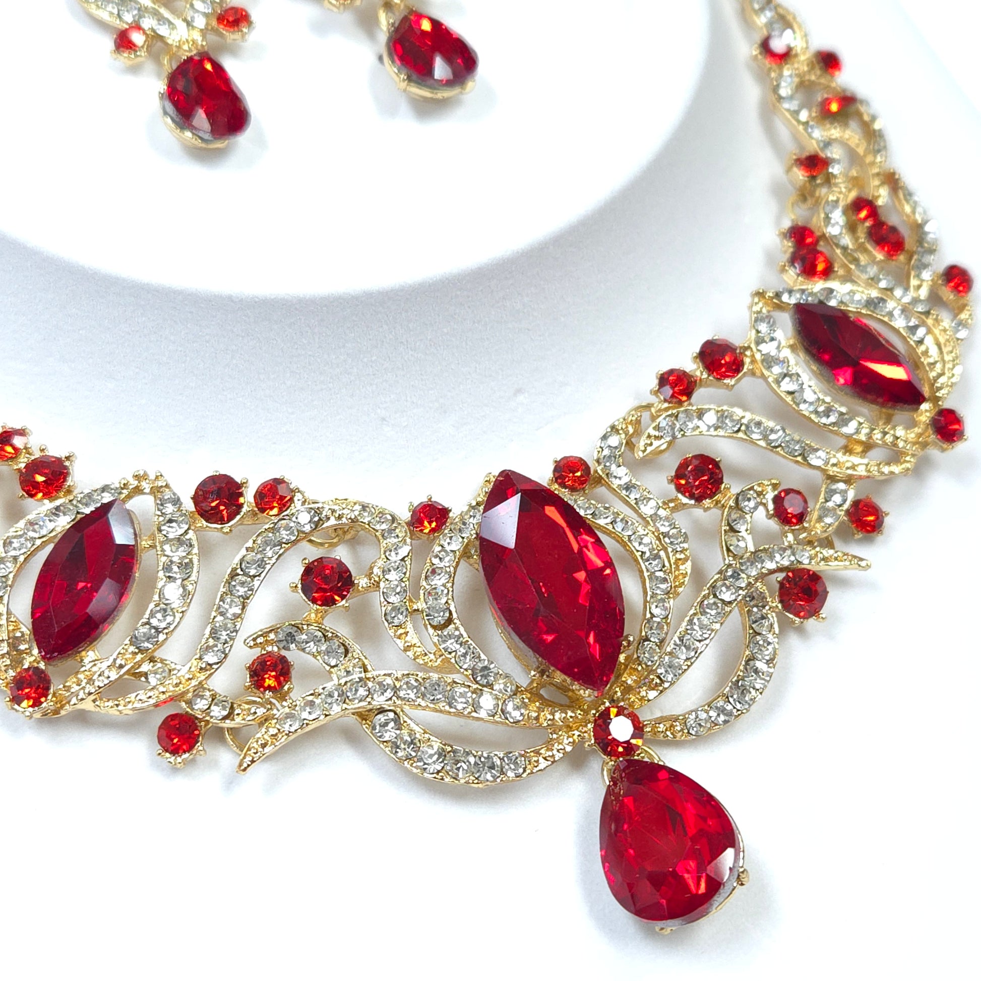 Jewelry set with red gemstones and gold accents on a white background