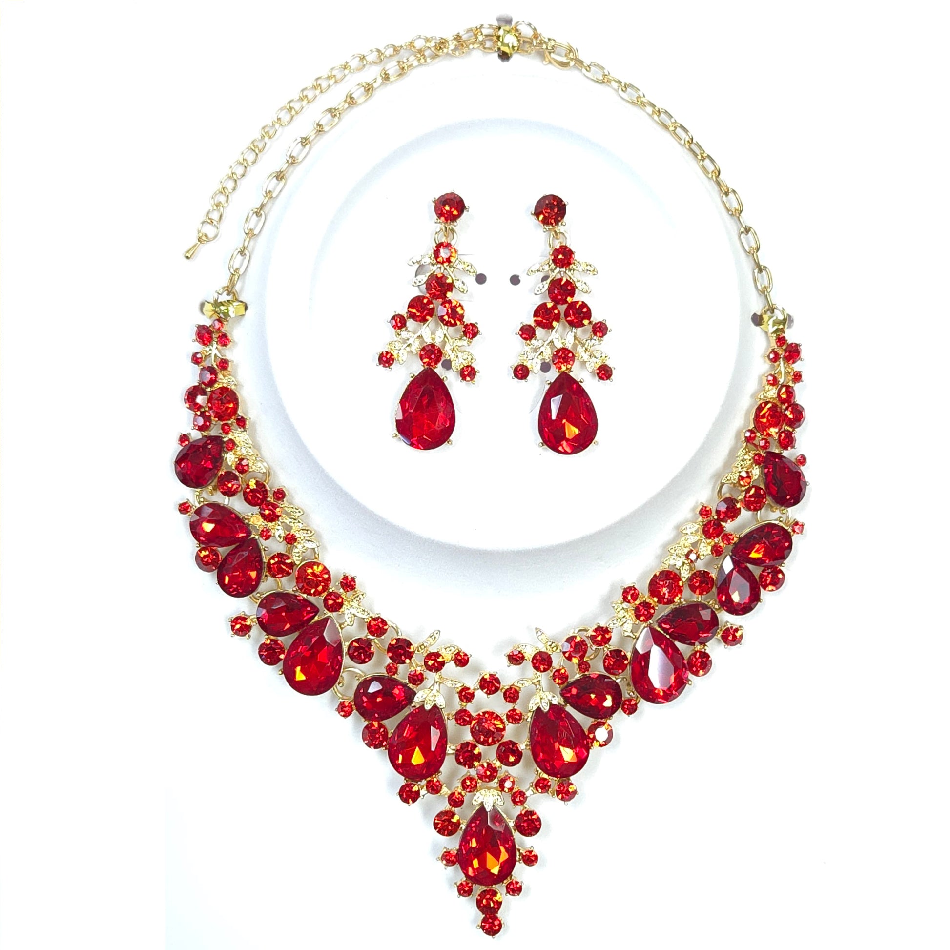 Jewelry set with red gemstones and gold accents on a white background