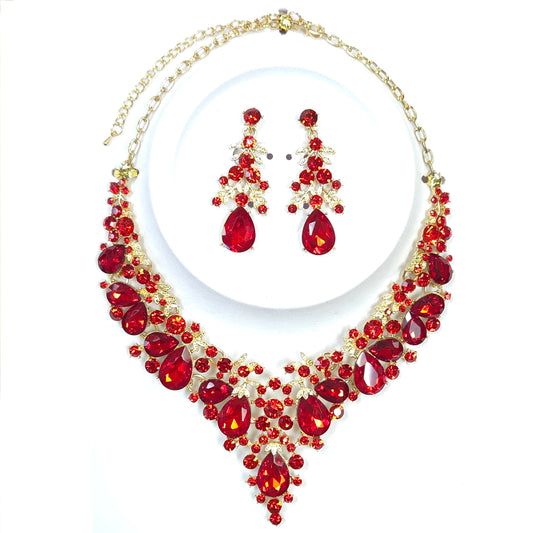 Jewelry set with red gemstones and gold accents on a white background