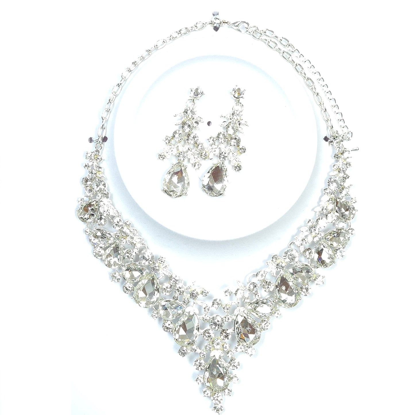 Silver necklace and earrings set on a white background