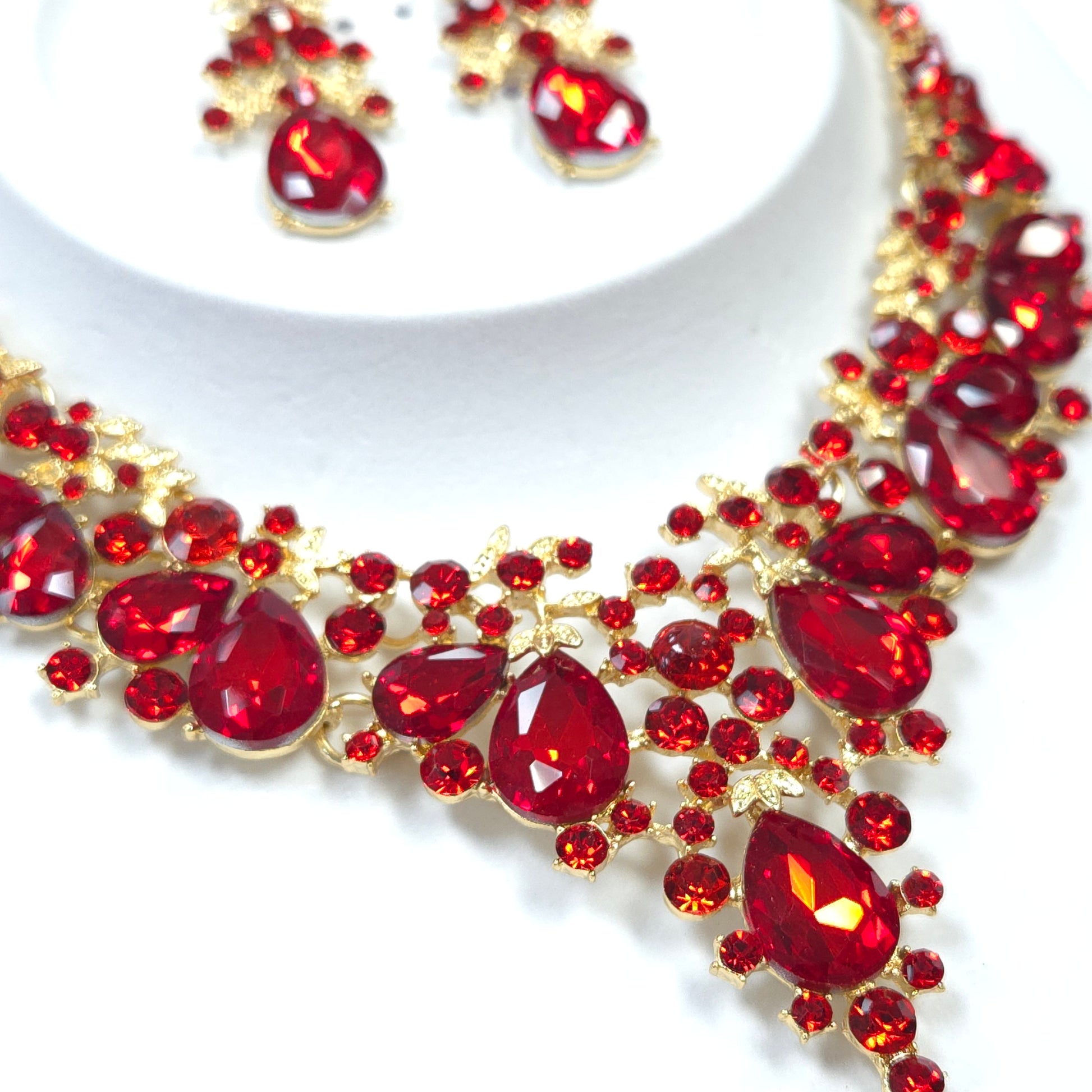 Jewelry set with red gemstones and gold accents on a white background