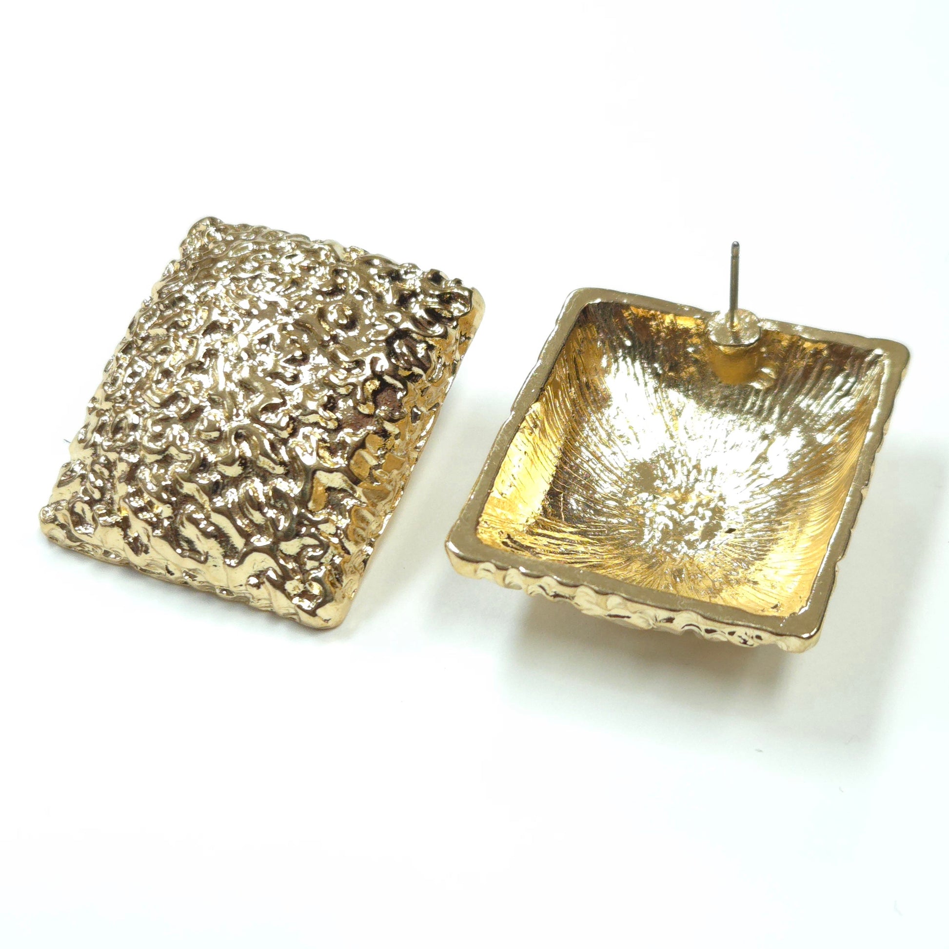 Gold textured square earrings on a white background