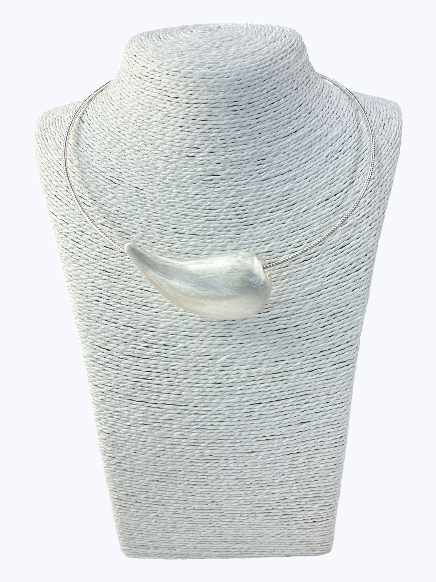 Silver necklace on a textured gray stand against a white background