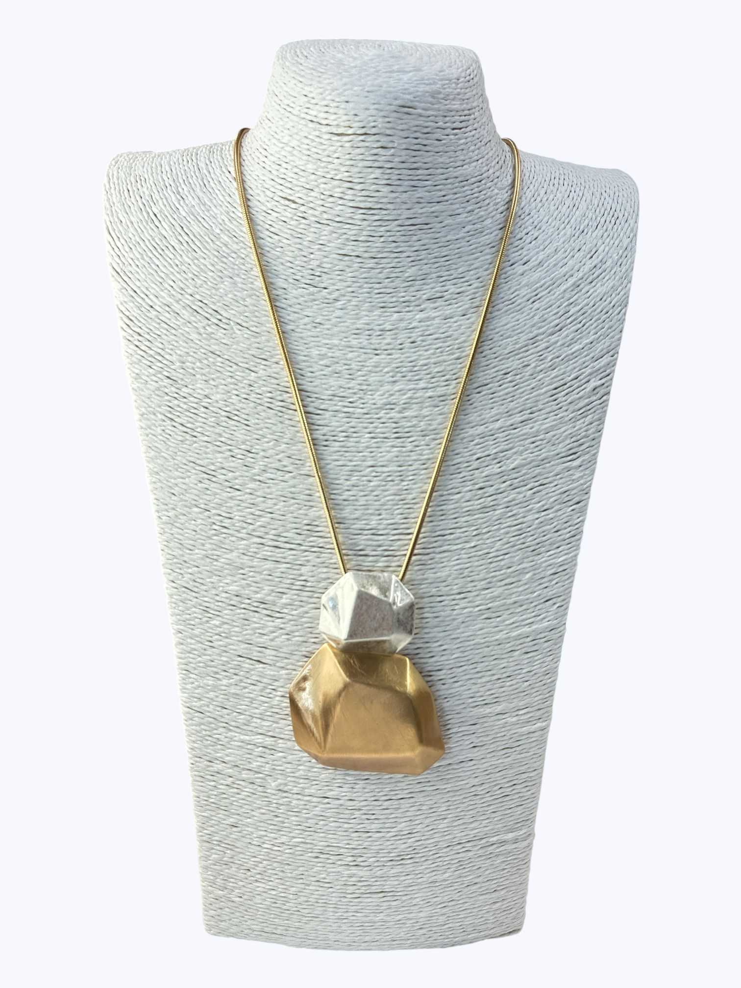 Necklace with a geometric pendant on a gray mannequin bust