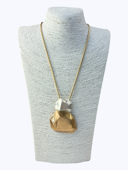 Necklace with a geometric pendant on a gray mannequin bust