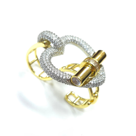 Gold and silver ring with intricate design on a white background