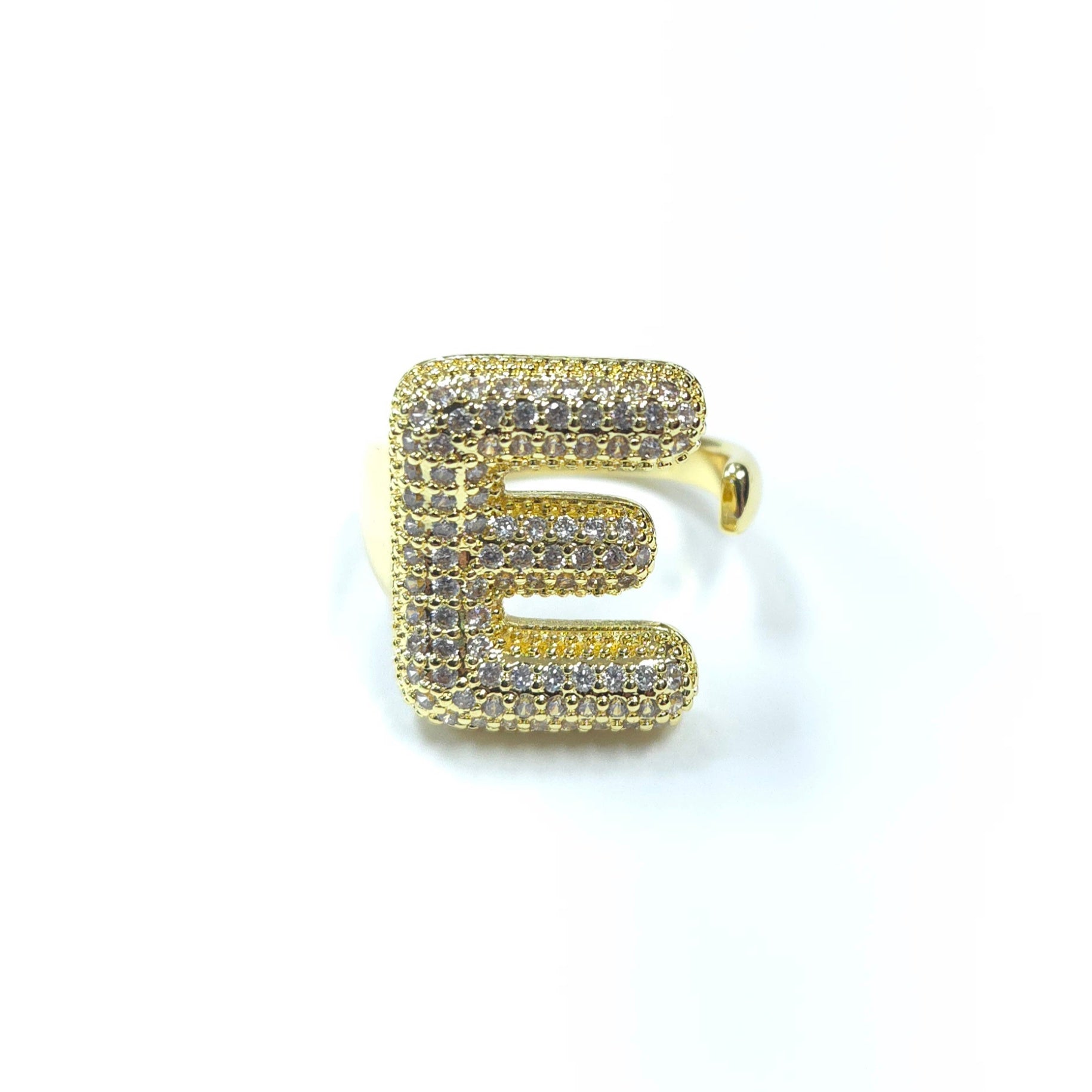 Gold letter 'E' pendant with gemstones on a white background