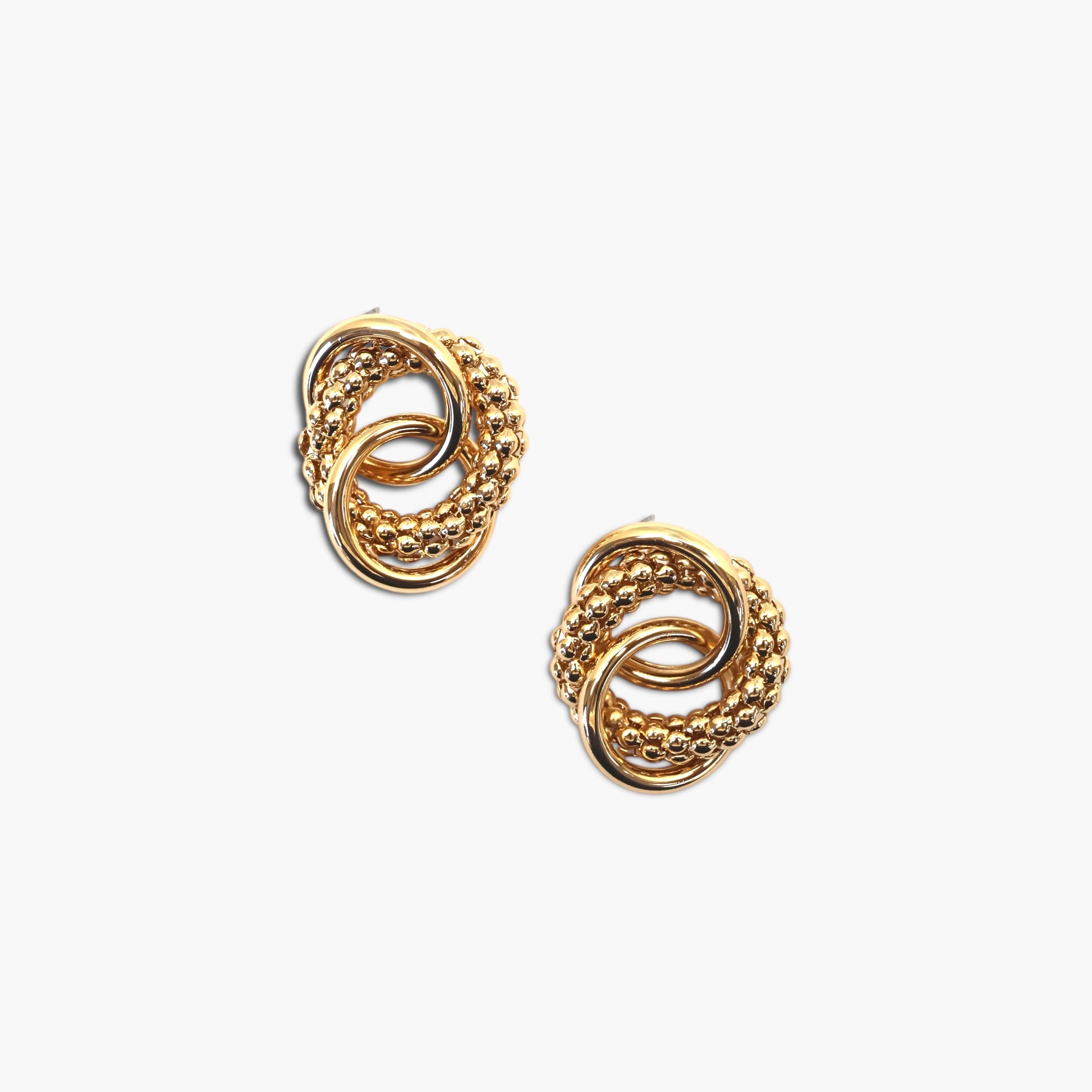 Interlocking knot stud earrings with textured and polished circular detailing in a modern boutique style.
