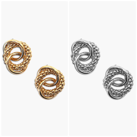 Interlocking knot stud earrings with textured and polished circular detailing in a modern boutique style.
