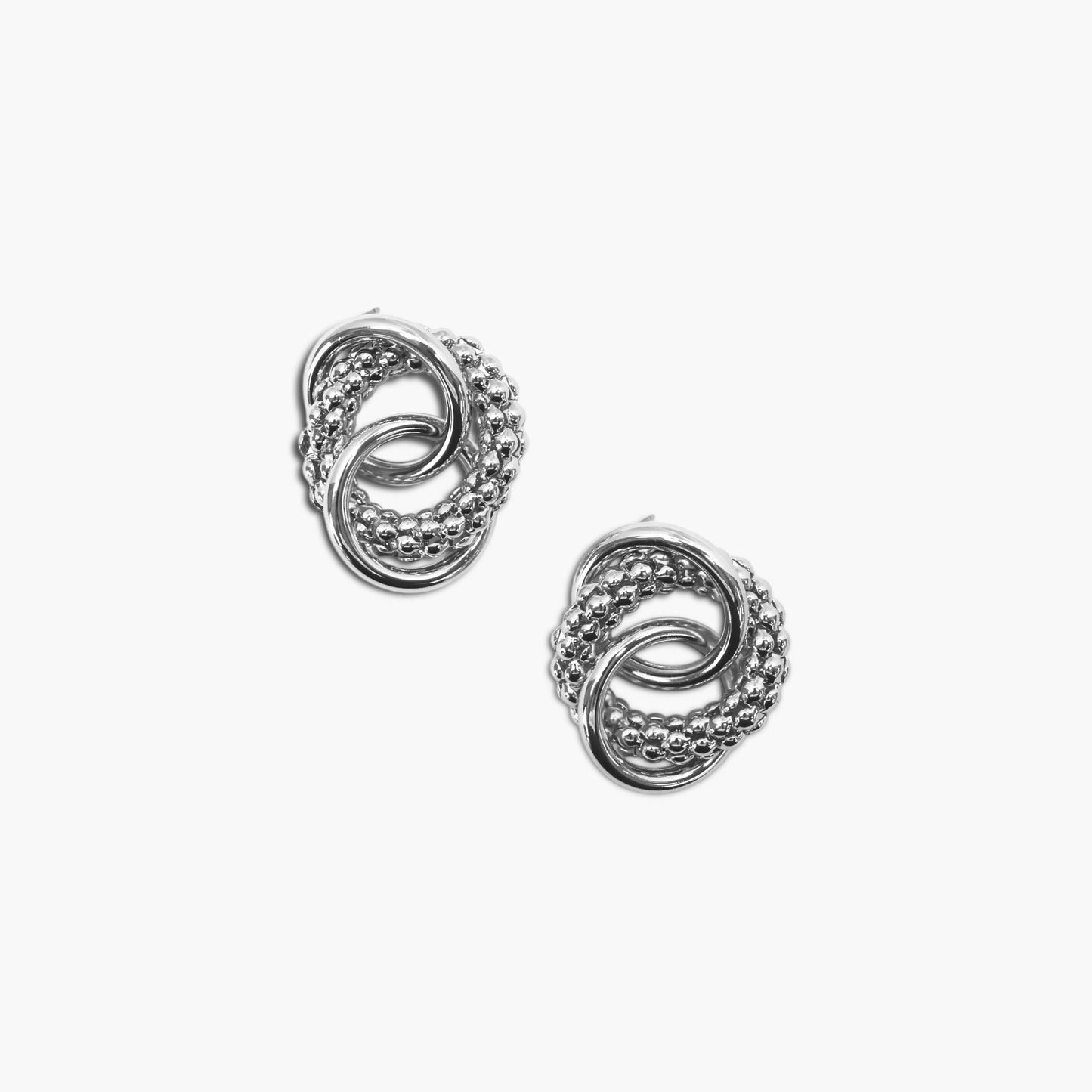 Interlocking knot stud earrings with textured and polished circular detailing in a modern boutique style.