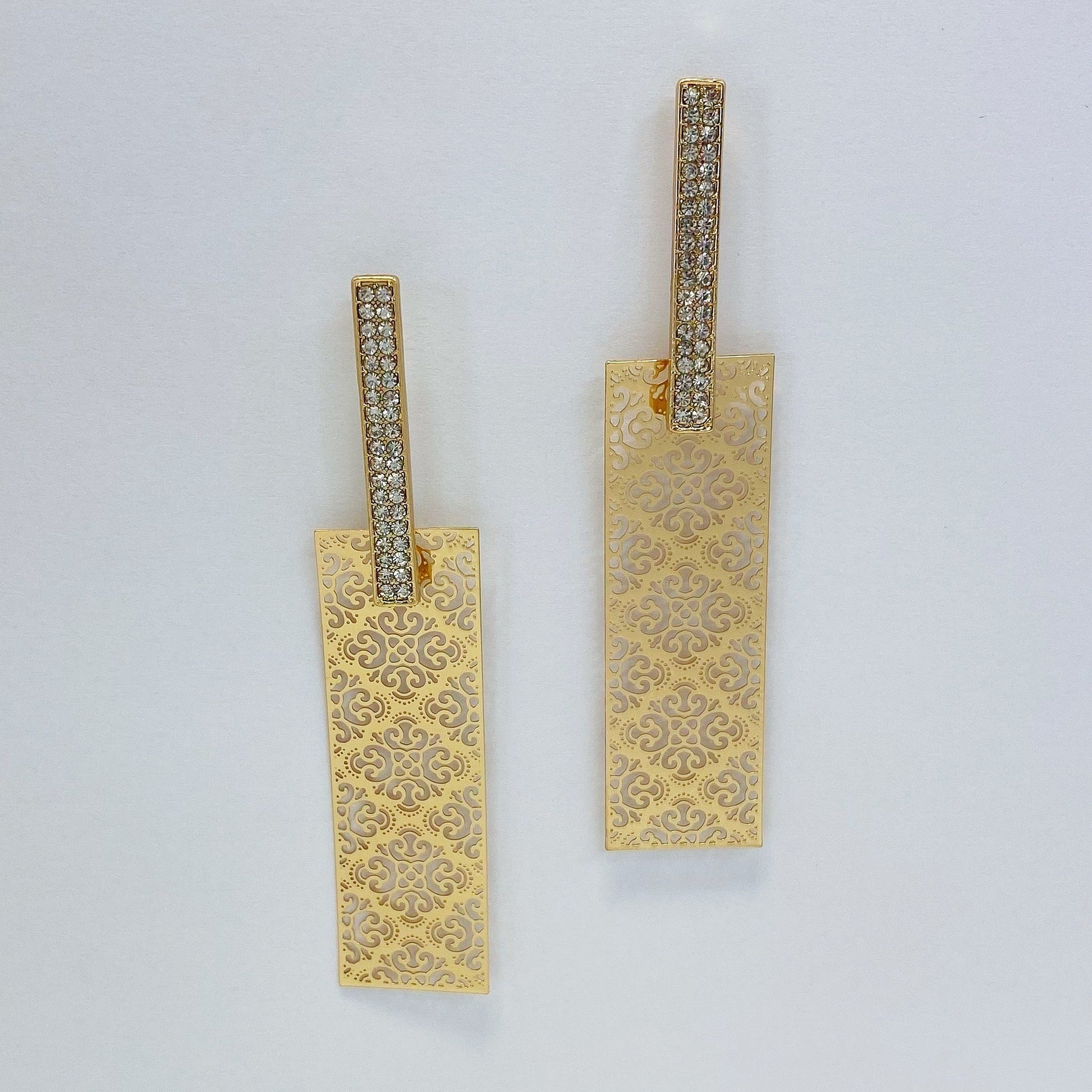 A pair of gold earrings on a white background