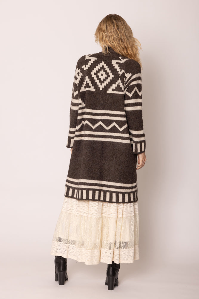 A girl wearing a brown poncho showing back part.