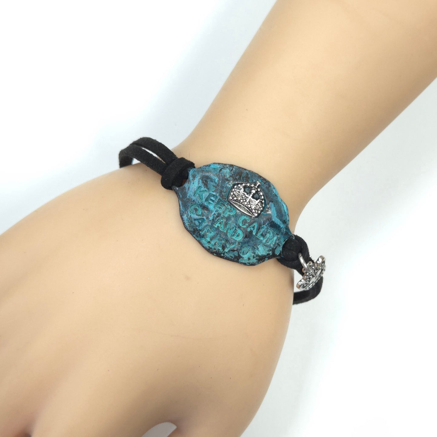 Turquoise bracelet with black cord on a wrist against a white background