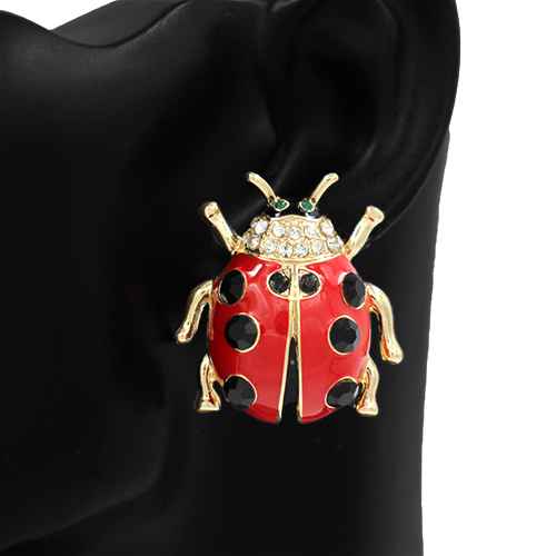 Red ladybug brooch with gold accents on a black background