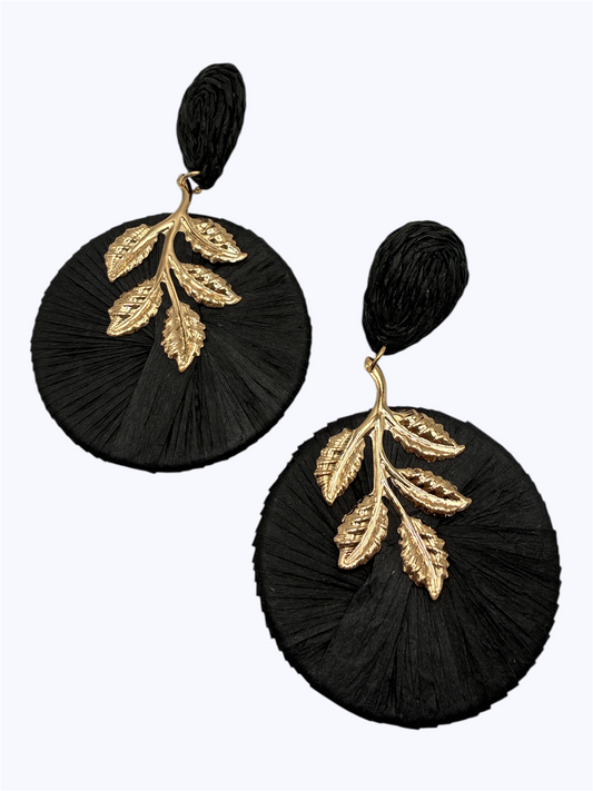 Oversized raffia disc drop earrings featuring woven circular detailing with gold tone leaf accents and textured stud tops.