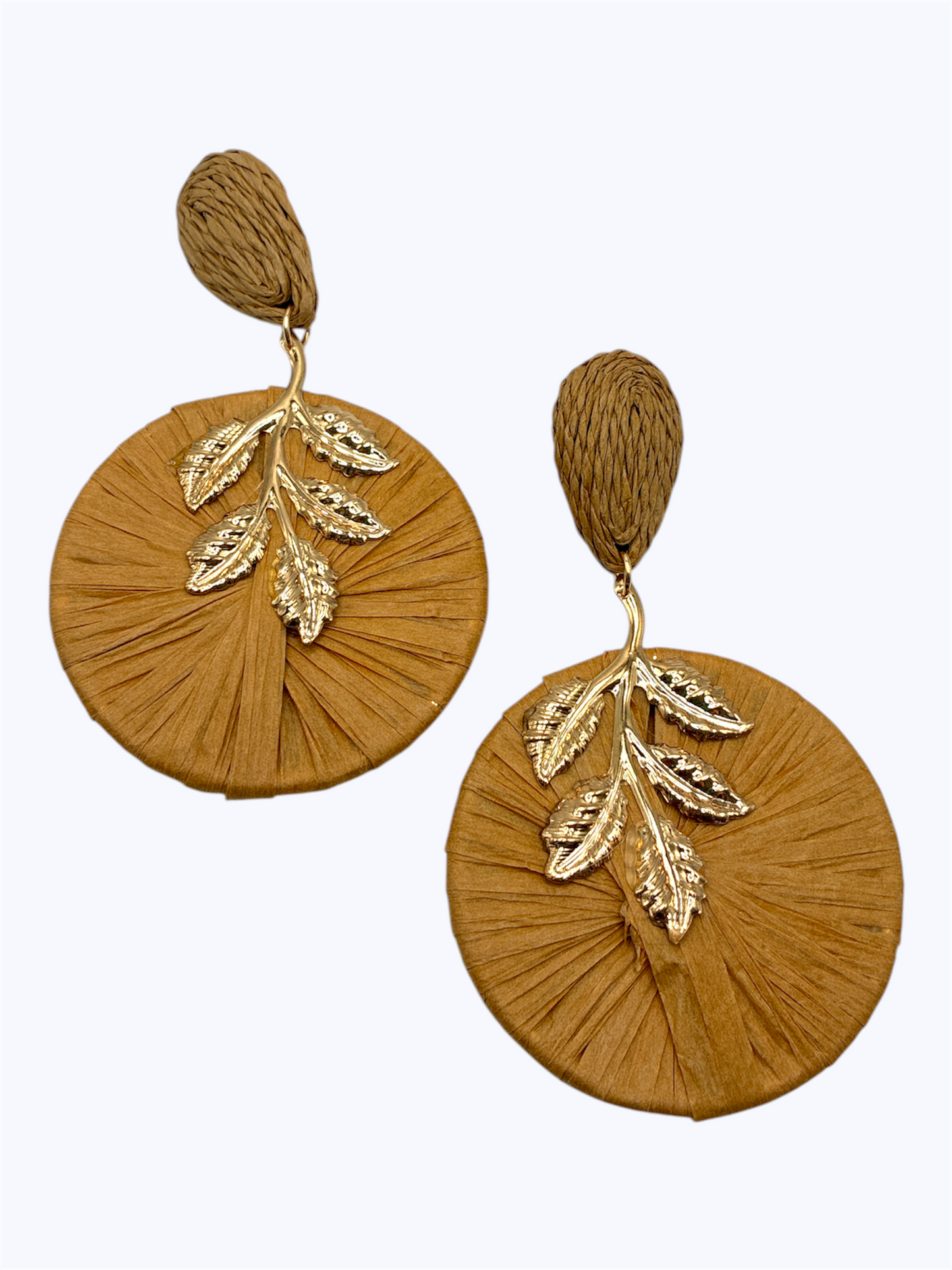 Oversized raffia disc drop earrings featuring woven circular detailing with gold tone leaf accents and textured stud tops.