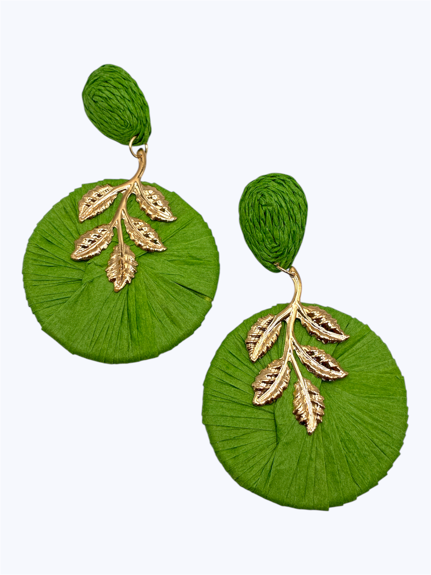 Oversized raffia disc drop earrings featuring woven circular detailing with gold tone leaf accents and textured stud tops.