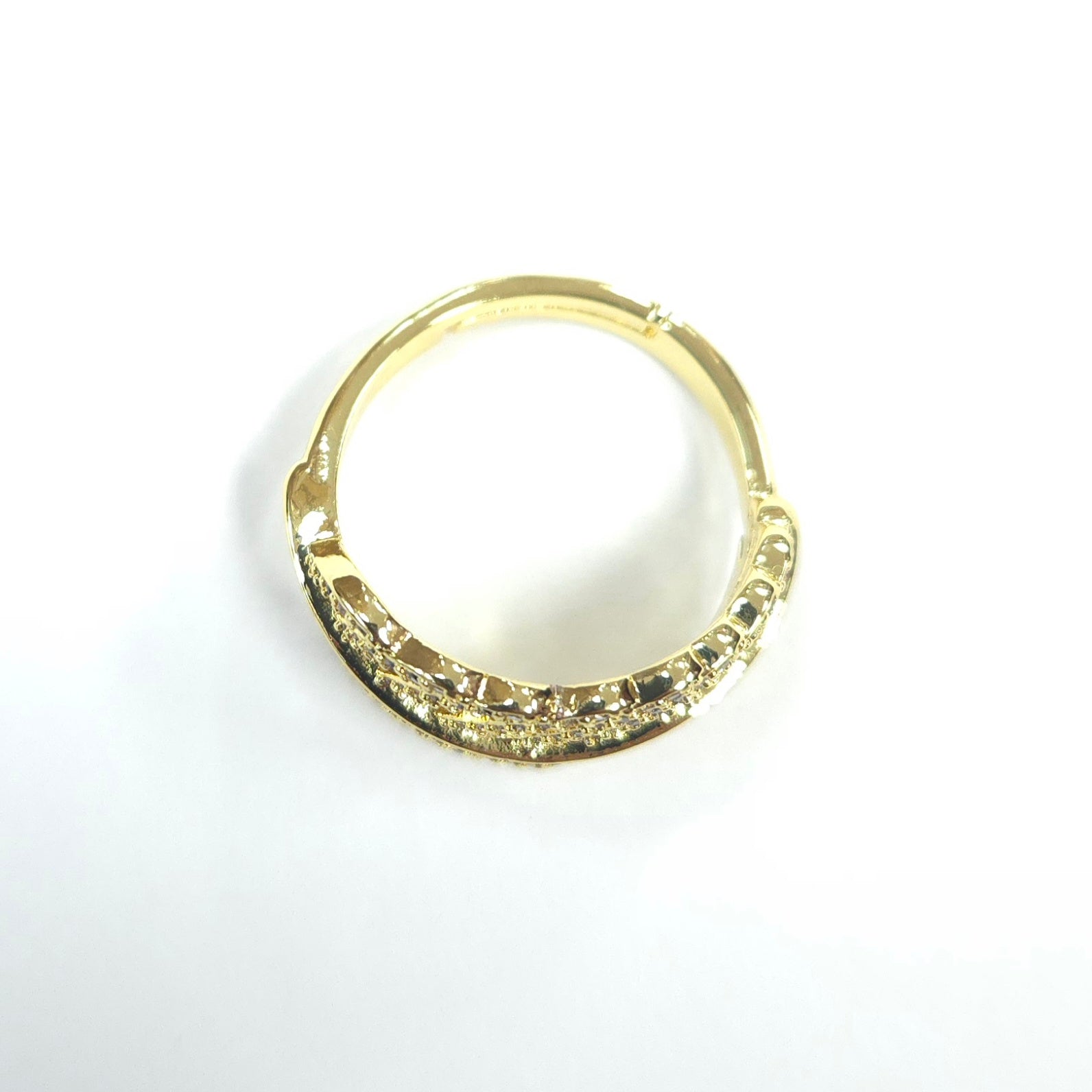 Gold ring with embedded stones on a white background