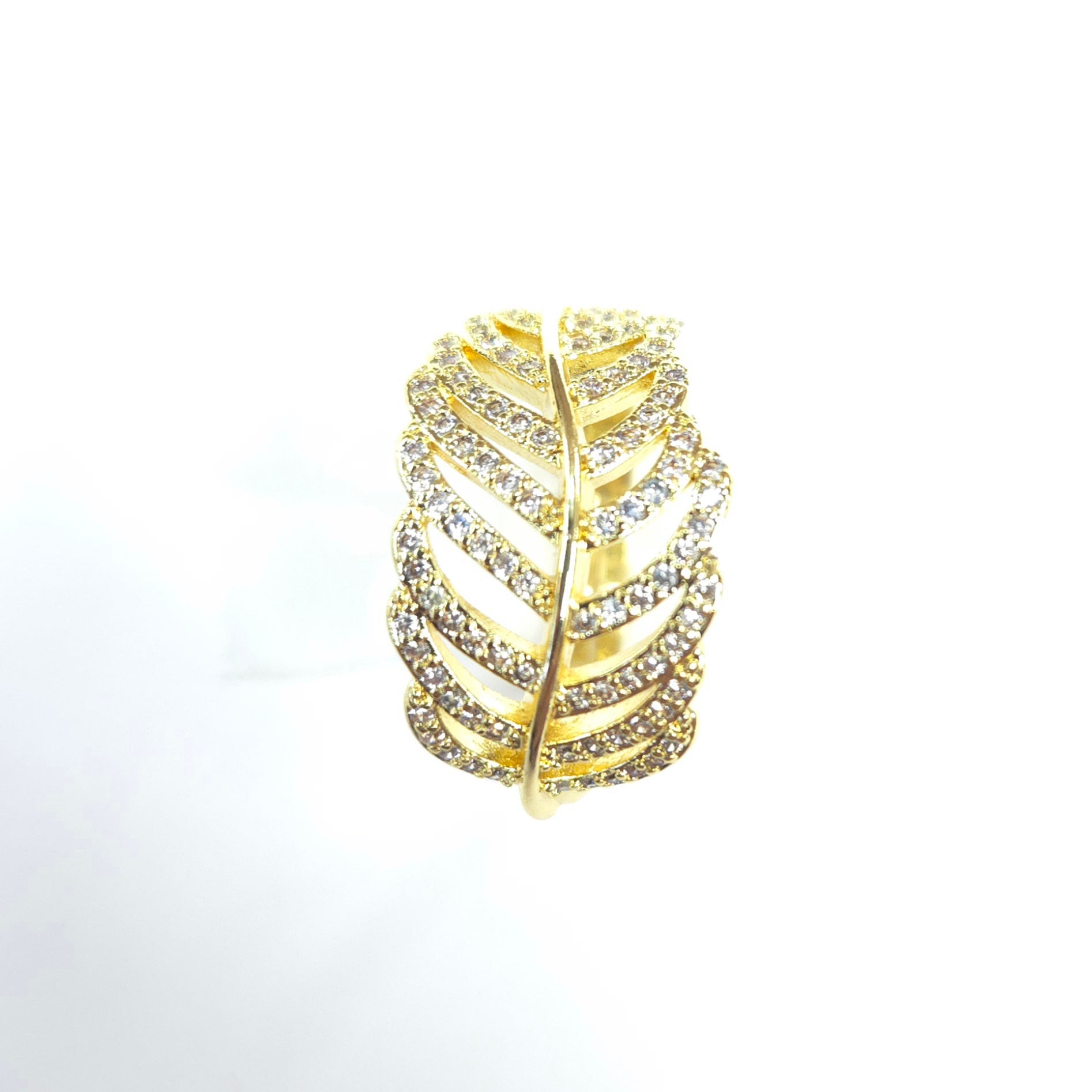 Gold leaf-shaped ring with embedded crystals on a white background