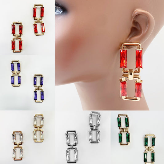A collection of earrings displayed on a mannequin ear, featuring a vintage design with rhinestones in various colors such as red, blue, green, and clear.