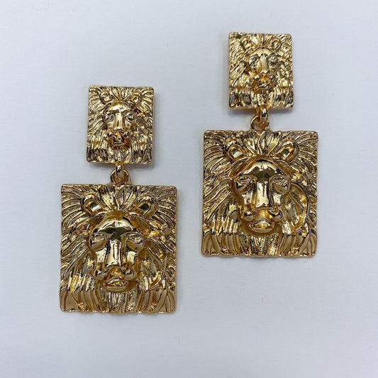 A pair of earrings which is lion-inspired on a white background