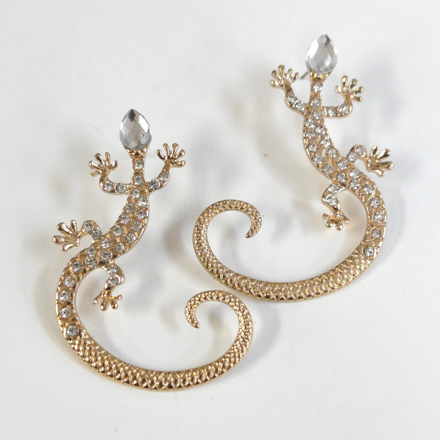 Gold lizard-shaped earrings with rhinestones on a white background