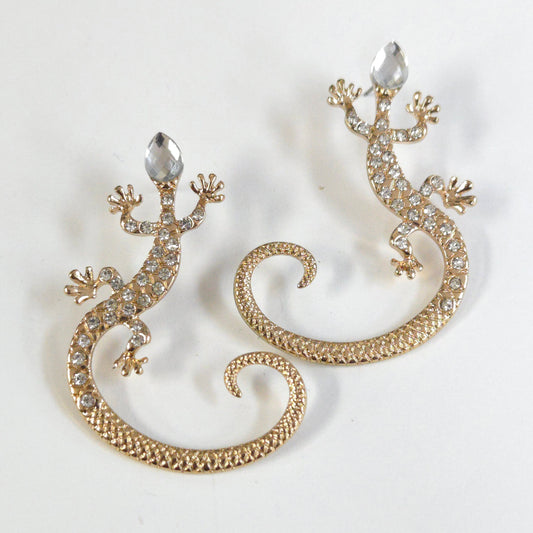 Gold lizard-shaped earrings with rhinestones on a white background