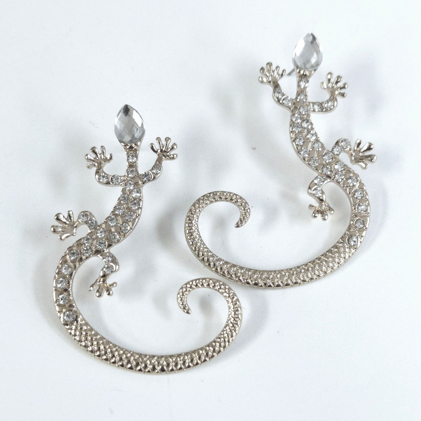 Silver lizard-shaped earrings on a white background